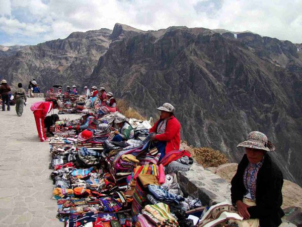 Culture of South America women sell colourful textiles 